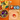 Colorful wooden tops on a wooden surface with an orange background